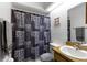 Well-lit bathroom featuring a shower, wooden vanity, and a functional layout at 12307 Villager Ct, Tampa, FL 33625