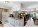 Bright kitchen opening to the living room, featuring white tile flooring and seamless flow for entertaining at 12307 Villager Ct, Tampa, FL 33625