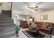 Cozy living room featuring comfortable seating, tile floors, and a staircase, designed for relaxation and entertainment at 12307 Villager Ct, Tampa, FL 33625