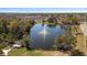 Aerial view of a pond with a fountain, surrounded by lush trees and residential areas, offers serene views at 12307 Villager Ct, Tampa, FL 33625