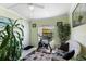 Bright sun room, a workout room, featuring green walls, large windows, and indoor plants, creating a rejuvenating space at 12307 Villager Ct, Tampa, FL 33625