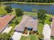 Aerial view of a home with a screened pool and a serene pond view, surrounded by lush landscaping and mature trees at 12309 Creek Edge Dr, Riverview, FL 33579