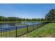 Peaceful backyard view overlooking a scenic pond, complemented by a secure black fence for privacy and safety at 12309 Creek Edge Dr, Riverview, FL 33579