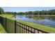 The backyard features a black fence bordering a serene pond, offering picturesque views and a sense of tranquility at 12309 Creek Edge Dr, Riverview, FL 33579