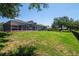 Expansive backyard with lush lawn, screened-in porch, and black fence, ideal for outdoor activities and serene relaxation at 12309 Creek Edge Dr, Riverview, FL 33579