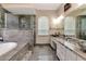 Modern bathroom featuring dual vanity, glass shower, soaking tub, and stylish fixtures at 12309 Creek Edge Dr, Riverview, FL 33579