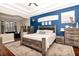 Well-lit bedroom with blue accent wall, wood furnishings, neutral carpeting, and a sitting area at 12309 Creek Edge Dr, Riverview, FL 33579