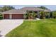 Charming home with a well-manicured lawn, three-car garage, and beautifully landscaped front yard with mature palms at 12309 Creek Edge Dr, Riverview, FL 33579