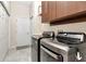 Laundry room featuring tile flooring and modern appliances, with cabinets for storage at 12309 Creek Edge Dr, Riverview, FL 33579