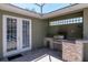 Outdoor kitchen featuring built-in grill, granite counters and white doors at 12309 Creek Edge Dr, Riverview, FL 33579