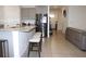 Bright kitchen with bar seating, stainless steel fridge and view into the entryway at 13327 Waterleaf Garden Cir, Riverview, FL 33579