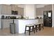 Bright kitchen with island, bar seating, granite countertops, stainless steel appliances and gray cabinets at 13327 Waterleaf Garden Cir, Riverview, FL 33579
