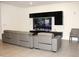 Comfortable living room with modern gray leather seating and a large television with sleek black shelving at 13327 Waterleaf Garden Cir, Riverview, FL 33579