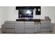 Comfortable living room with modern gray leather seating and a large television with sleek black shelving at 13327 Waterleaf Garden Cir, Riverview, FL 33579