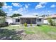 Spacious backyard with white fencing, lush green lawn, and an enclosed back porch at 13523 Prestwick Dr, Riverview, FL 33579