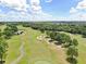 Scenic aerial view of a golf course with ponds and sand traps nestled among mature trees at 13523 Prestwick Dr, Riverview, FL 33579