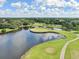 Captivating aerial shot of a golf course showcasing a unique island green and reflective pond at 13523 Prestwick Dr, Riverview, FL 33579