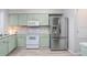 Well-lit kitchen with stainless steel appliances and light green cabinets at 13523 Prestwick Dr, Riverview, FL 33579