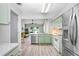 Airy kitchen with stainless steel appliances and light green cabinets at 13523 Prestwick Dr, Riverview, FL 33579