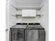 Convenient laundry room featuring a side-by-side washer and dryer with shelving at 13523 Prestwick Dr, Riverview, FL 33579