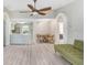 Open-concept living space with wood-look floors, ceiling fan, and seamless flow to kitchen and dining area at 13523 Prestwick Dr, Riverview, FL 33579