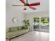 Light-filled living room with a ceiling fan, sliding glass doors, and a comfortable couch at 13523 Prestwick Dr, Riverview, FL 33579