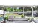 Screened-in porch featuring a comfortable chair, potted plants, and a view of the fenced backyard at 13523 Prestwick Dr, Riverview, FL 33579