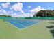 Community tennis court with green fencing and a beautiful blue sky with clouds at 13523 Prestwick Dr, Riverview, FL 33579