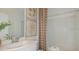 Clean bathroom featuring a well-maintained shower-tub combo and botanical decor at 13556 Tropical Breeze Way, Hudson, FL 34669