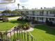 Exterior view of a two-story building with green spaces and mature trees at 138 36Th N Ave # 206W, St Petersburg, FL 33704