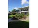 Exterior view of a white two story condo with landscaped garden and green lawn at 138 36Th N Ave # 206W, St Petersburg, FL 33704