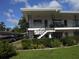 Exterior of a condo complex with a white facade, iron railings, and covered parking at 138 36Th N Ave # 206W, St Petersburg, FL 33704