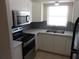 Updated kitchen with stainless steel appliances, white cabinetry, and double sink at 138 36Th N Ave # 206W, St Petersburg, FL 33704