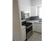 Kitchen with stainless steel appliances, white cabinets and blue patterned backsplash at 138 36Th N Ave # 206W, St Petersburg, FL 33704