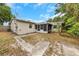 Backyard view showcasing the screened patio, partial fencing, and tropical foliage at 1472 Belcher S Rd, Largo, FL 33771