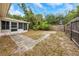 Fenced backyard featuring tropical landscaping and a screened porch area for outdoor living at 1472 Belcher S Rd, Largo, FL 33771