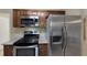 View of the kitchen featuring stainless steel appliances, granite countertops, wood cabinets and tile floor at 1472 Belcher S Rd, Largo, FL 33771