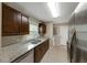 Kitchen view featuring granite counters, stainless appliances, and tile floor in a neutral color scheme at 1472 Belcher S Rd, Largo, FL 33771