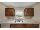 Kitchen area showcasing granite counters, dual basin sink and window with wooden cabinets at 1472 Belcher S Rd, Largo, FL 33771