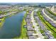 Aerial view of a community with a large lake, lush landscaping, and well-maintained streets at 16115 Mount Holly Dr, Bradenton, FL 34211