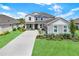 Beautiful two-story home boasts a manicured lawn, long driveway, and lovely landscaping at 16115 Mount Holly Dr, Bradenton, FL 34211