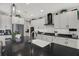 Spacious kitchen offers white cabinetry, sleek black countertops, and stainless steel appliances and island sink at 16115 Mount Holly Dr, Bradenton, FL 34211