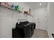 A well-lit laundry room with black appliances and storage shelves at 16115 Mount Holly Dr, Bradenton, FL 34211