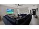 Modern living room with a large sectional sofa, a ceiling fan, and a big screen television at 16115 Mount Holly Dr, Bradenton, FL 34211