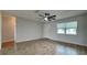 Bright bedroom featuring wood-look floors, a ceiling fan, a large window, and neutral paint at 1701 Hibiscus S Cir, Oldsmar, FL 34677