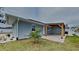 Back exterior view featuring backyard and covered parking structure at 1701 Hibiscus S Cir, Oldsmar, FL 34677
