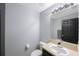 Clean and simple powder room with neutral tones and a large mirror at 17809 Sandpine Trace Way, Tampa, FL 33647