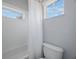 Clean and bright bathroom featuring a tub and shower combination, white tile and a window at 17809 Sandpine Trace Way, Tampa, FL 33647