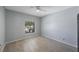 Bright bedroom with gray walls, a ceiling fan, and a window view of lush greenery at 17809 Sandpine Trace Way, Tampa, FL 33647