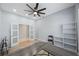 Well lit bedroom featuring wood floors, a ceiling fan, french doors, and a white storage unit at 17809 Sandpine Trace Way, Tampa, FL 33647